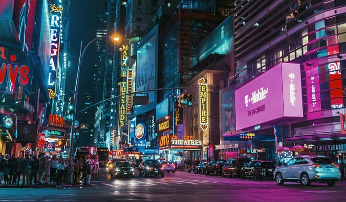 A crowded city street with digital billboards